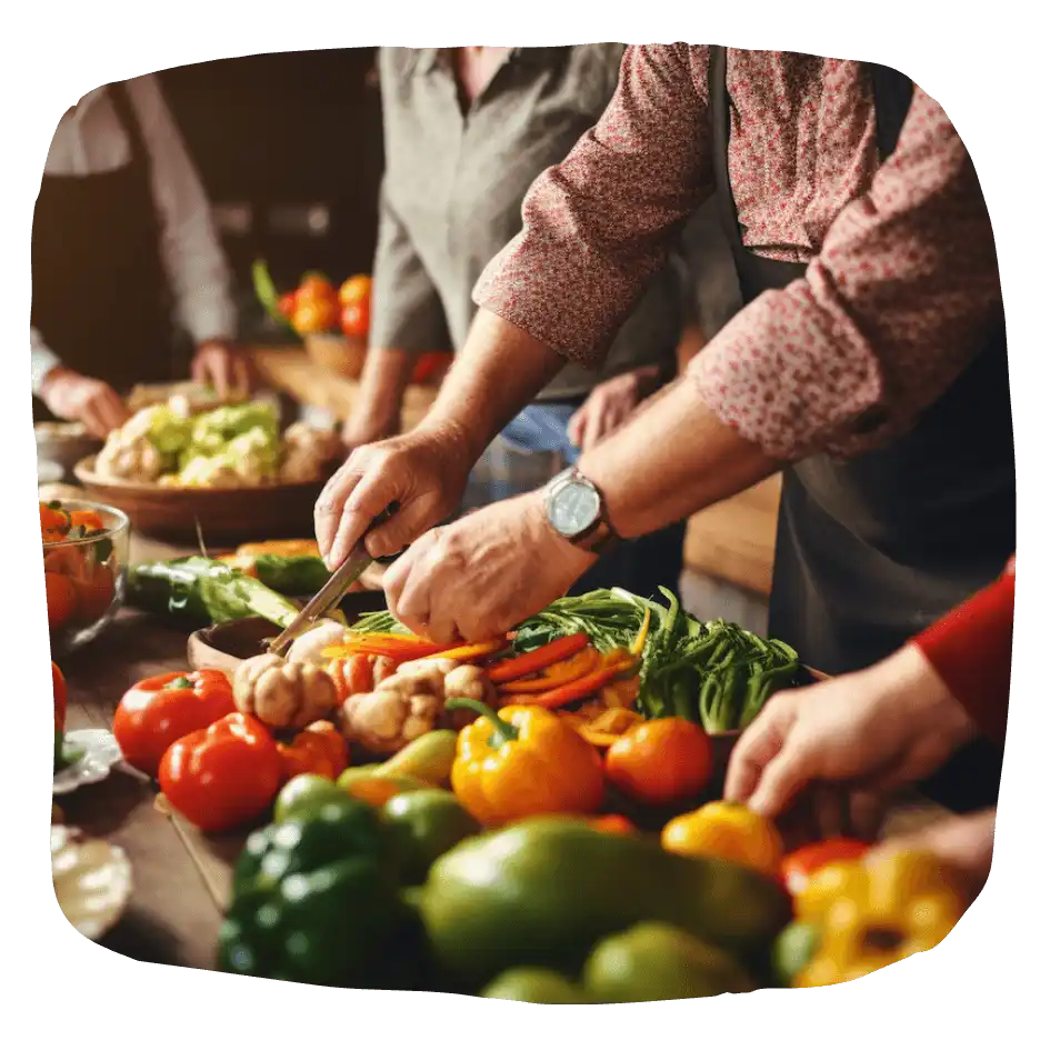 fresh vegetables on a table being prepared for preservation by many sets of hands