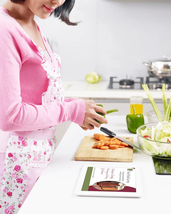 Person prepping vegetables in a kitchen with an ipad recipe